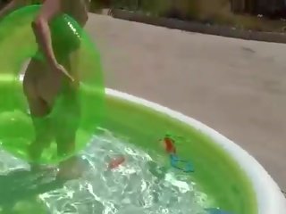 Playful blond teenager im bikini streifen und neckt im die schwimmbad